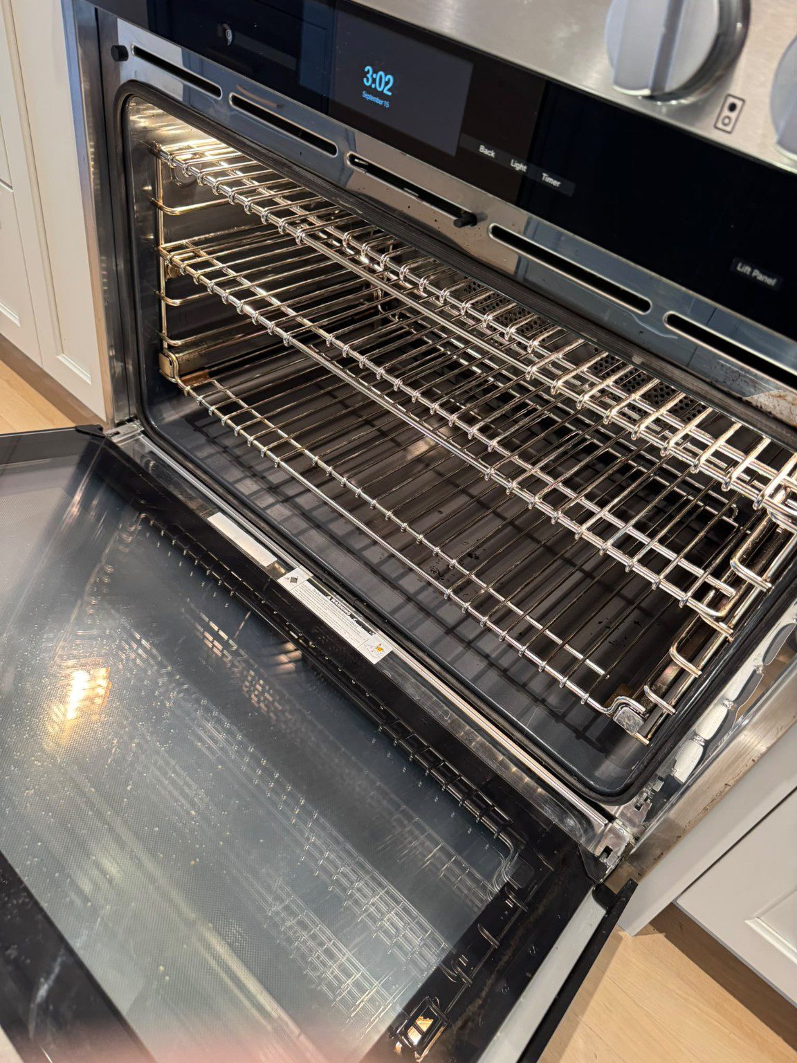 Open built-in oven showing its interior, metal racks and inner door glass