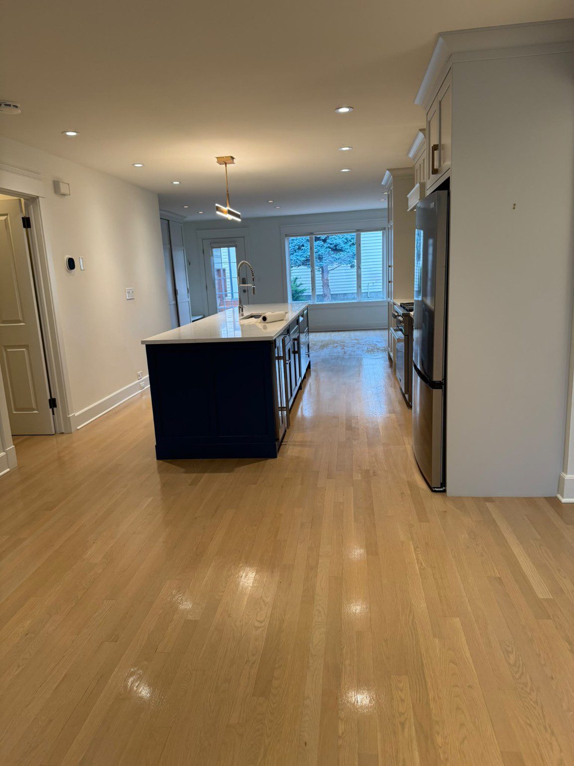 Open kitchen and living area with a central island and wood flooring