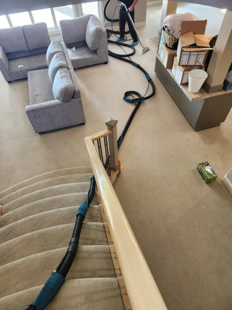AD Spotless carpet steam-cleaning equipment across a carpeted staircase and living room.
