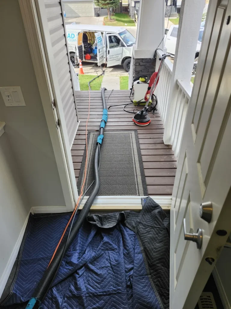 AD Spotless van and steam cleaning equipment at a property entrance